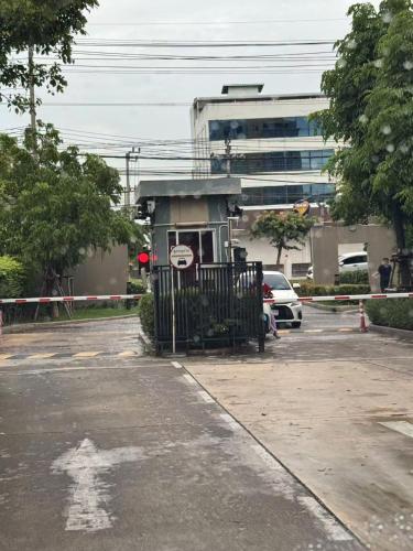 a parking lot with a gate in front of a building at Condo located 5 minutes away from Suvarnabhumi Airport by taxi for cooking, short-term rental, and long-term rental in Sathani Lat Krabang