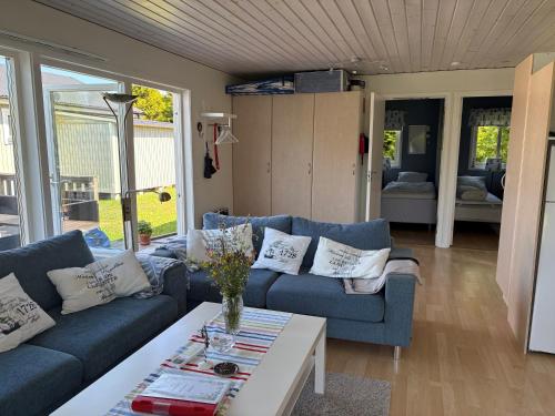 a living room with blue couches and a table at Stuga i Gnisvärd in Tofta