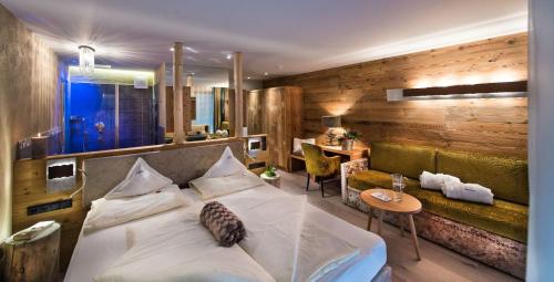 a hotel room with a bed and a table at Hotel Santner Alpine Sport & Relax in Alpe di Siusi