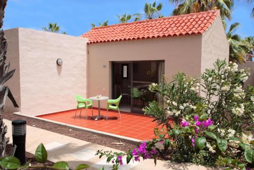 a house with a patio and a table and chairs at Caybeach Caleta in Caleta De Fuste