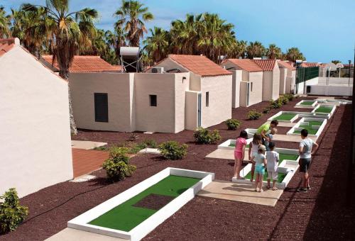 a group of people standing in a courtyard with houses at Caybeach Caleta in Caleta De Fuste