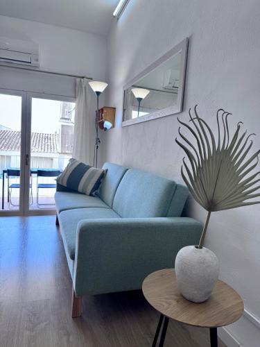 a blue couch in a living room with a table at Apartaments Aeroclub in Empuriabrava