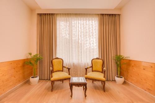 two chairs and a table in front of a window at Keys Select by Lemon Tree Hotels, Kufri, Shimla in Shimla