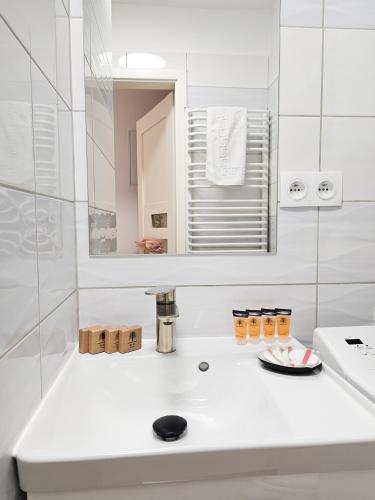 a white bathroom with a sink and a mirror at Tabago Studio 36 Brzeg Chopina in Brzeg