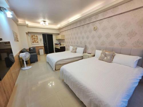 a hotel room with two beds and a television at Yuanben Mountain Hot Spring Homestay in Jiaoxi