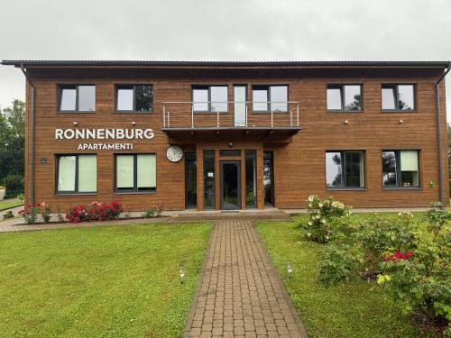 a building with a brick walkway in front of it at Ronnenburg apartamenti in Rauna