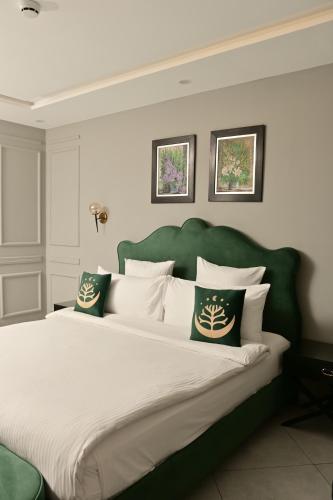 a large bed with a green headboard and white pillows at Villa Vista in Islamabad