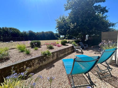 two chairs sitting in a garden with flowers at BRIT HOTEL Lannion-Perros Guirec in Lannion