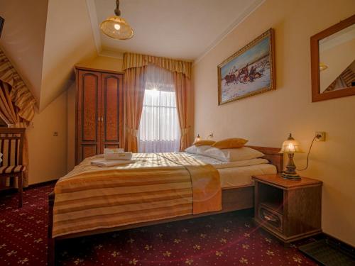 a bedroom with a large bed and a window at Pensjonat Zbójecki Dwór - ATRAKCYJNY PAKIET ŚWIĄTECZNY - blisko basenów termalnych i szlaków górskich in Bukowina Tatrzańska