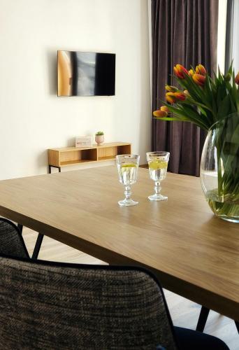 a wooden table with two glasses and a vase of flowers at Hotel Bardo in Bardo
