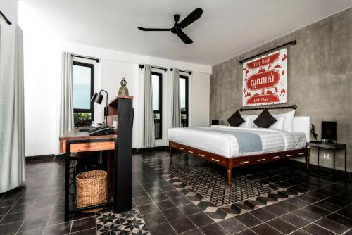 a bedroom with a bed and a desk and a bed sidx sidx sidx at Aquarius Hotel and Urban Resort in Phnom Penh