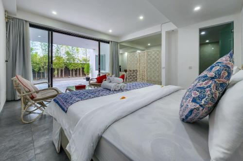 a bedroom with a large bed and a large window at Emilia 1 Bedroom Apartment Seminyak by Nagisa Bali in Kerobokan