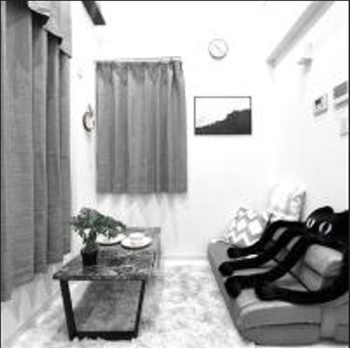 un soggiorno con un divano e un tavolo di Shinjuku sumika5 a Tokyo