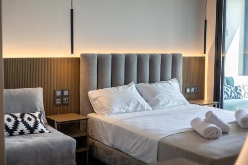 a bedroom with a large bed with two white towels on it at Sea View Serenity Βeachfront & Pool 105 in Salamís