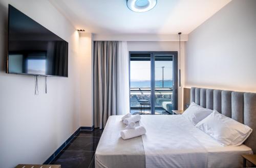 a hotel room with a bed with a teddy bear on it at Sea View Serenity Βeachfront & Pool 105 in Salamís
