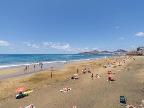 eine Gruppe von Menschen an einem Strand mit Blick auf das Meer in der Unterkunft Edison Building By CanariasGetaway in Guanarteme
