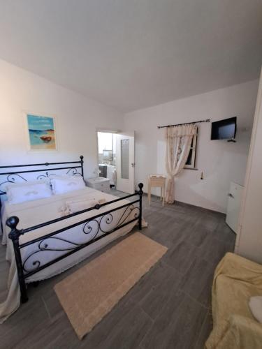 a bedroom with a bed and a television in it at B&B li salcuneddi in Aglientu
