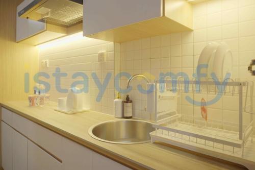 a sink in a kitchen with a sign on the wall at Studio Pollux Habibie B1617 City View in Batam Center