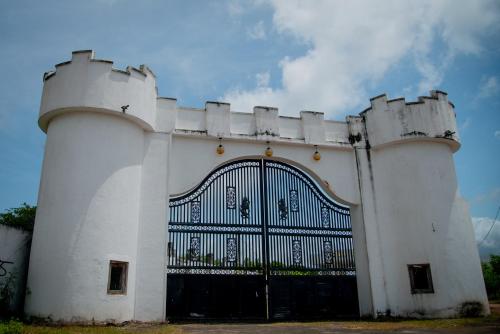 a white building with a gate in front of it at Grand Palace Hotel, Seeduwa in Seeduwa