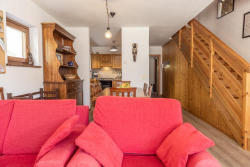 a living room with a red couch and a kitchen at Casa Cavina, ampia con giardino e garage in Venas