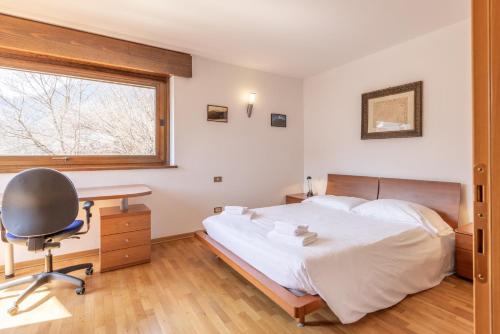 a bedroom with a bed and a desk and a chair at Casa Cavina, ampia con giardino e garage in Venas