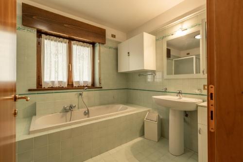 a bathroom with a bath tub and a sink at Casa Cavina, ampia con giardino e garage in Venas