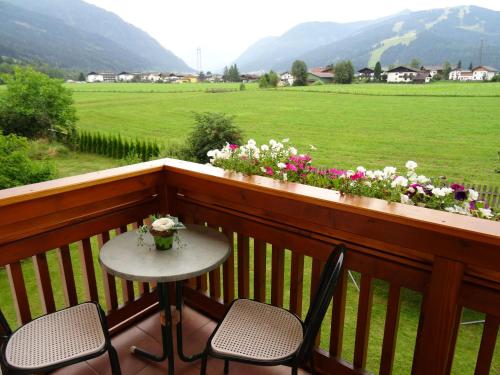 a table and chairs on a balcony with a field at Ferienwohnungen Reiter in Flachau