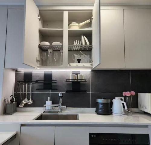 eine Küche mit weißen Schränken und einer Spüle in der Unterkunft Ocean GYM n Spa, free parking in Busan