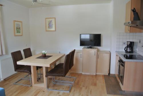 a kitchen with a table and chairs and a television at Ferienwohnungen Reiter in Flachau