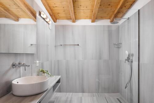 a white bathroom with a sink and a shower at Porto Castello Villas in Skiathos Town