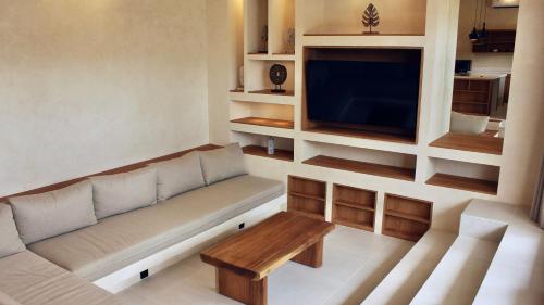 クタにあるMediterrania Villasのソファと薄型テレビのあるリビングルーム
