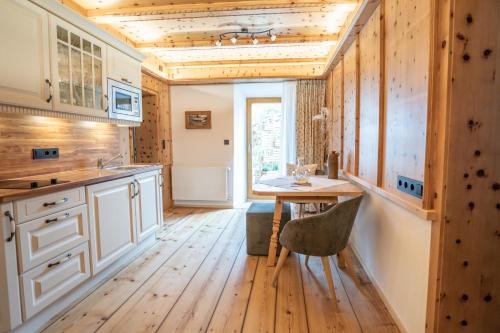 a kitchen with white cabinets and a wooden floor at Beim Nuihausa in Reit im Winkl