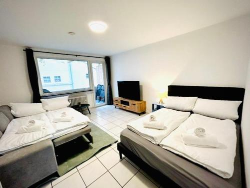 a bedroom with two beds and a large window at Modernes Studio Appartement im Herzen von Worms in Worms
