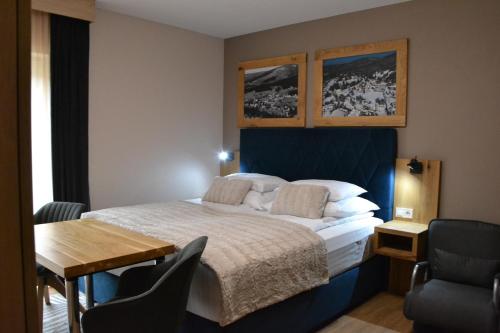 a bedroom with a bed and a table and chairs at Apartmány Špacír in Harrachov