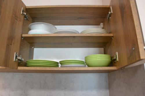 a wooden cabinet with plates and bowls in it at Apartmány Špacír in Harrachov