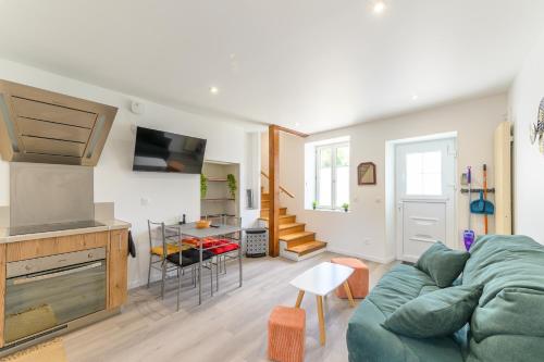 a living room with a green couch and a kitchen at Le Duplex Mouroux - 30min de Disneyland in Mouroux
