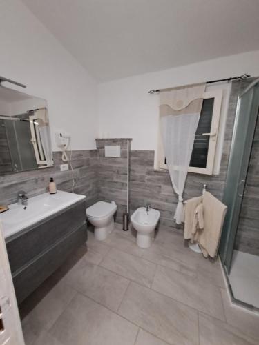 a bathroom with a tub and a toilet and a sink at B&B li salcuneddi in Aglientu
