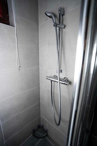 a shower with a hose in a bathroom at Holiday House Konuško in Šmarje pri Jelšah