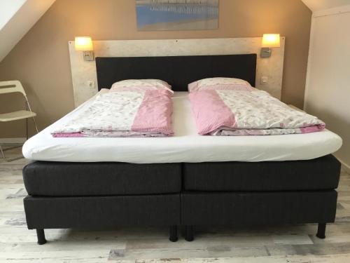 - un lit avec 2 oreillers roses dans l'établissement De Linden, à Egmond aan Zee