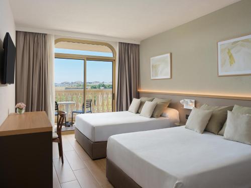 a hotel room with two beds and a balcony at Ponient Dorada Palace by PortAventura World in Salou
