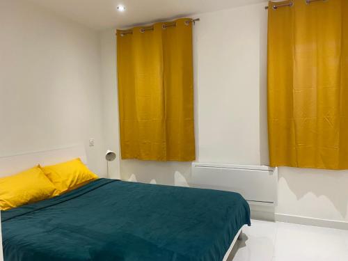 a bedroom with a bed with yellow and green sheets at Chambre privée en centre-ville in Trèbes