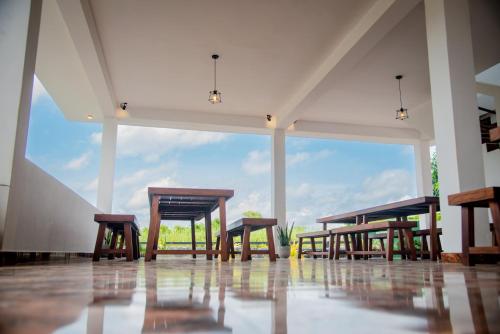 a group of wooden tables and chairs in a room at Grand Palace Hotel, Seeduwa in Seeduwa