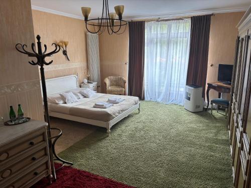 a hotel room with a bed and a desk and a room at Hotel Pałacyk Konin in Konin