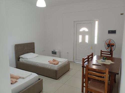 a bedroom with two beds and a desk and a table at Anna! in Ksamil