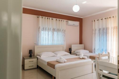 a bedroom with two beds and a window at Fjori's Apartments in Sarandë