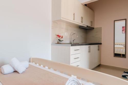 a kitchen with white cabinets and a sink at Fjori's Apartments in Sarandë