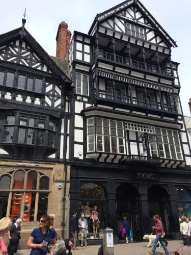 a black and white building with people walking in front of it at Elegant Apartment In Hamilton Square Free Parking in Birkenhead