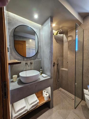 un baño con lavabo y espejo en Petries Studios, en Agioi Apostoli