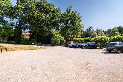 a group of cars parked in a parking lot at Hotel Les Ambres in Roussillon