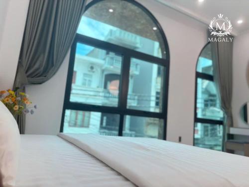 a bedroom with a bed and a window at Magaly Apartment & Hotel in Hai Phong